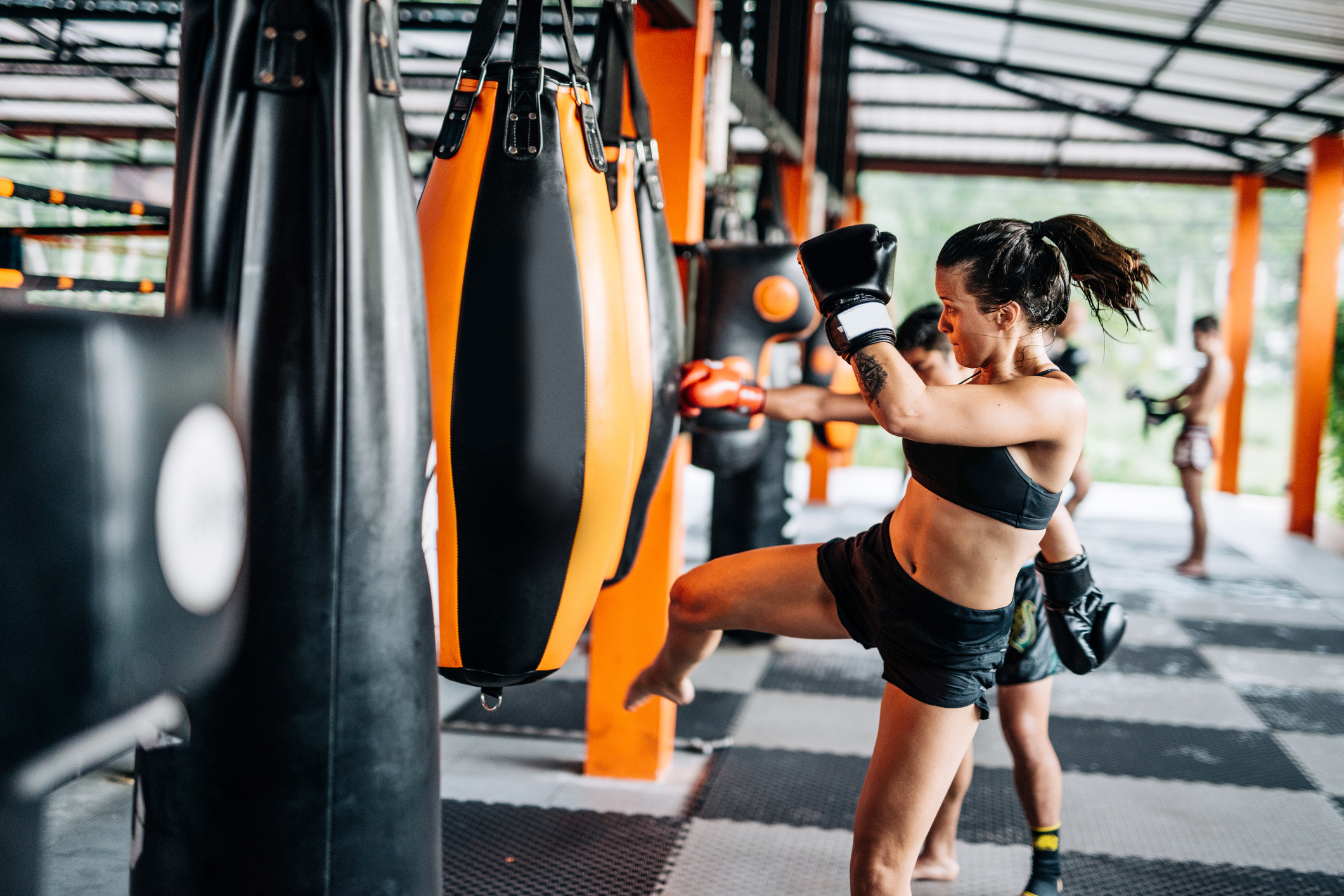 Female boxer kicking a boxing bag