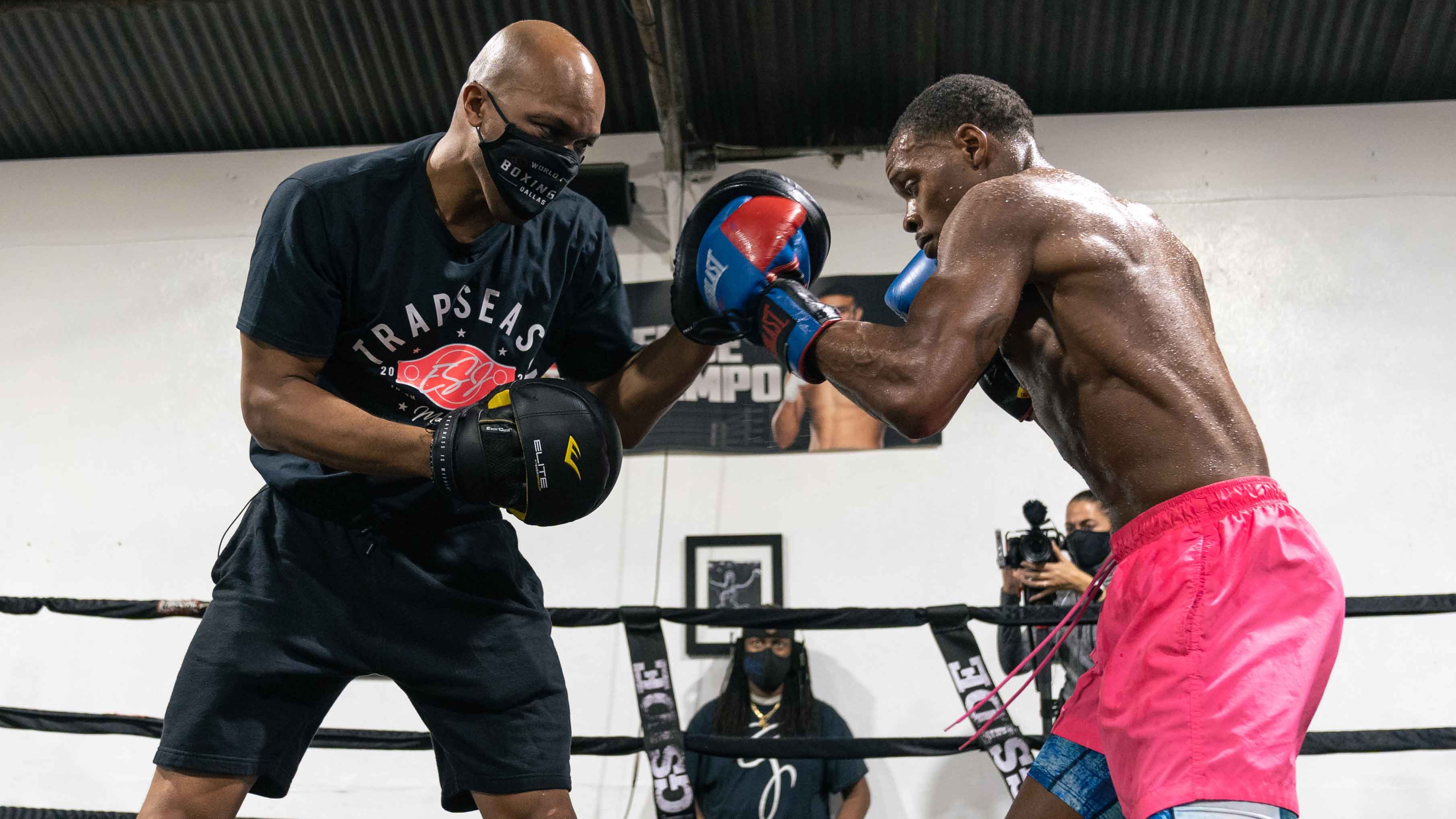 Trainer Derrick James in the ring training with a boxer.