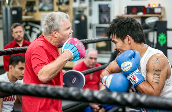Trainer Freddie Roach in the ring training with a boxer.